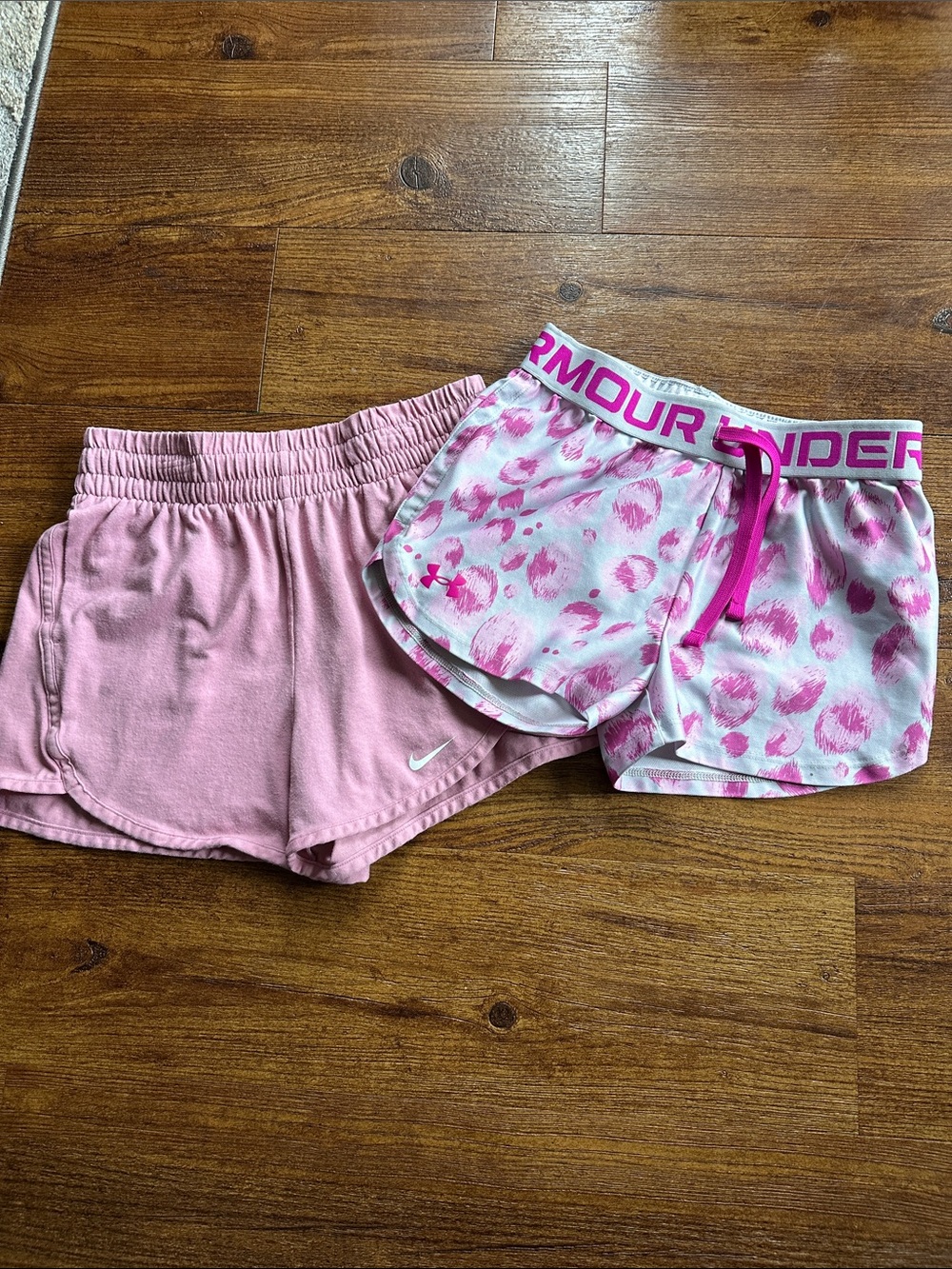 Girls shorts size M. Pink Nike with pockets and Under Armour pink/grey printed.